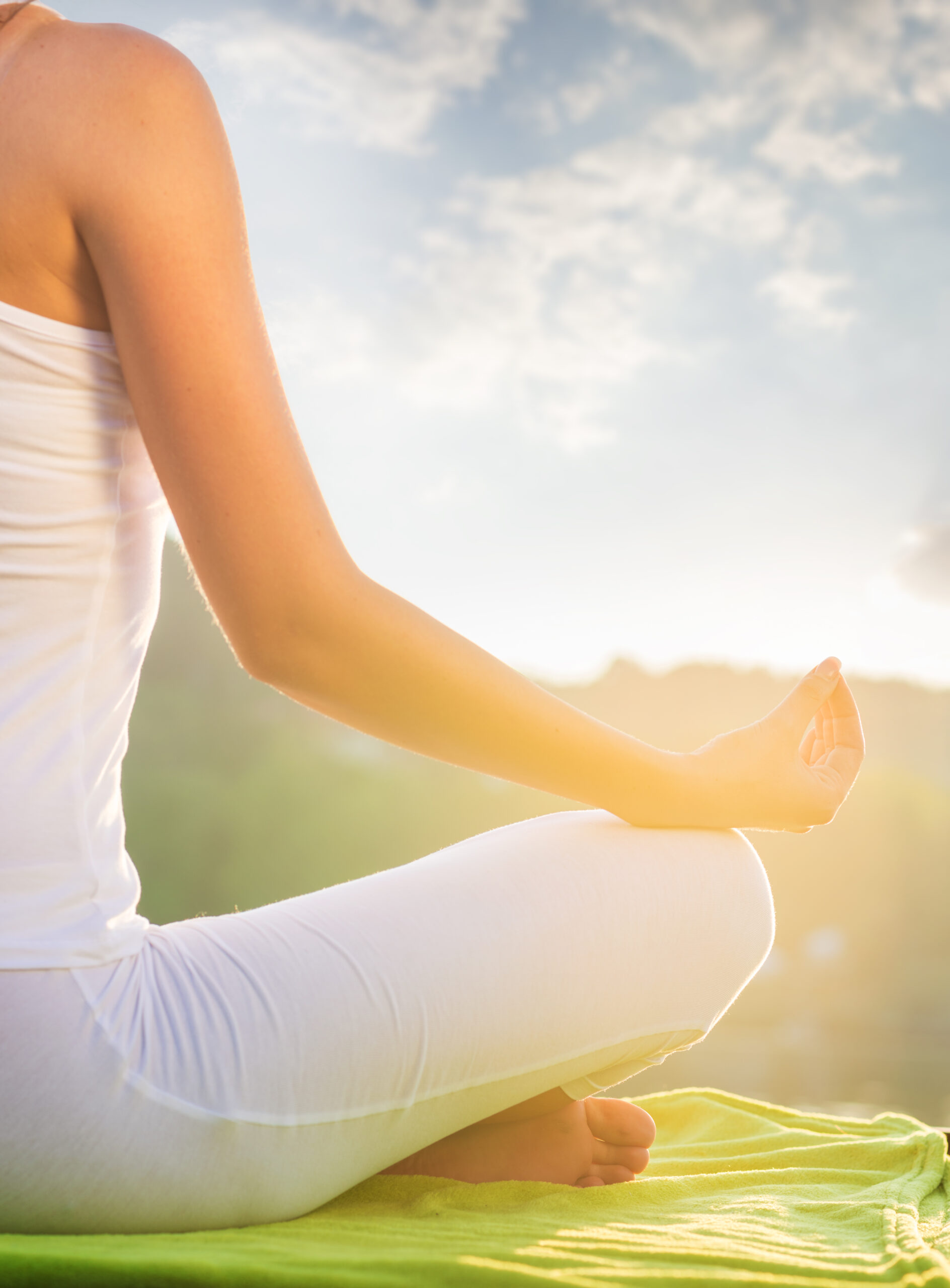 Woman doing yoga on the shore - half figure sitting